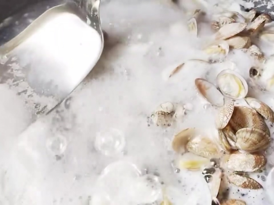 Una schiumarola di metallo che rimuove la schiuma dalla superficie dellacqua bollente.