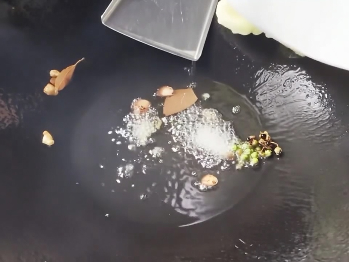 Germogli di bambù affettati e segmenti di mais saltati in un wok caldo con gli aromi.