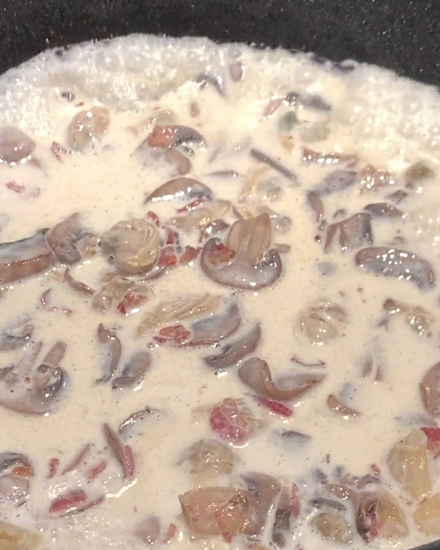Zuppa cremosa ai funghi con cubetti di patata in padella.