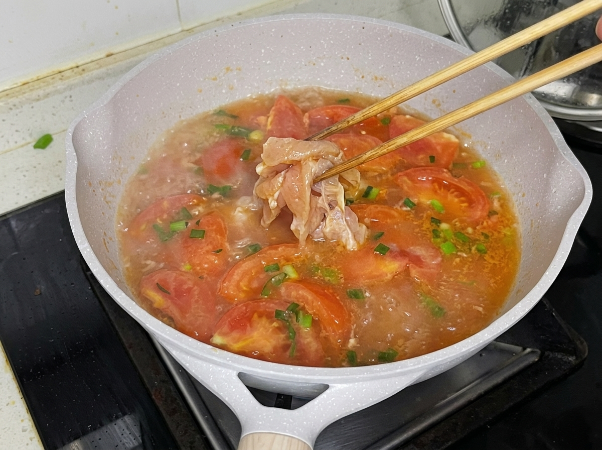 Pezzetti di pollo aggiunti delicatamente nel brodo bollente con le bacchette.