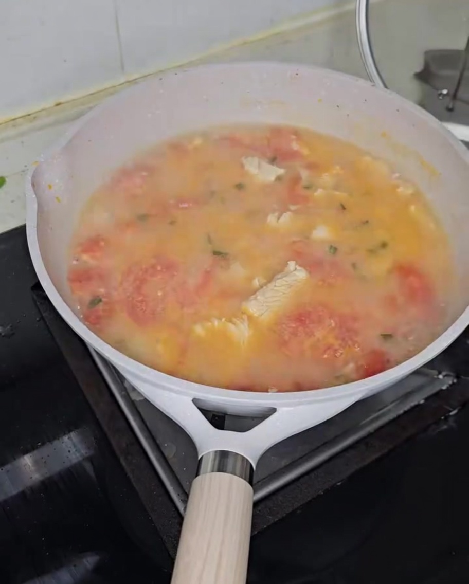 Gnocchetti di grano saraceno aggiunti nella zuppa di pomodoro e pollo che sobbolle.