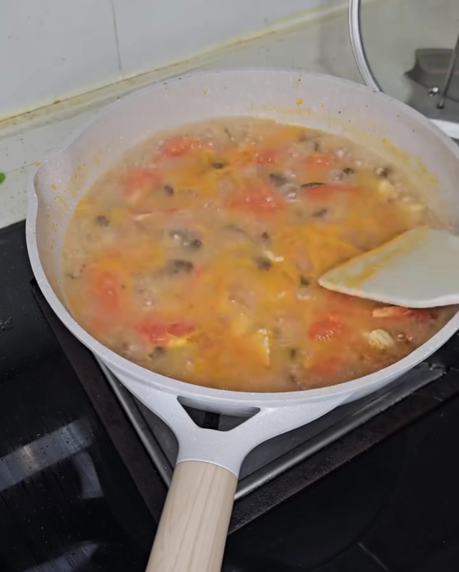 Cipollotto fresco tritato cosparso su una pentola di zuppa fumante.