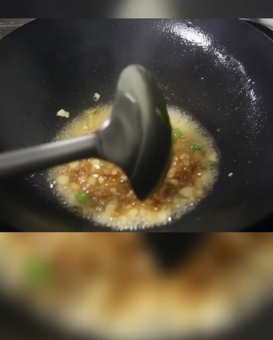 Cipollotti, carne a cubetti e patate che cuociono in un wok caldo con olio.