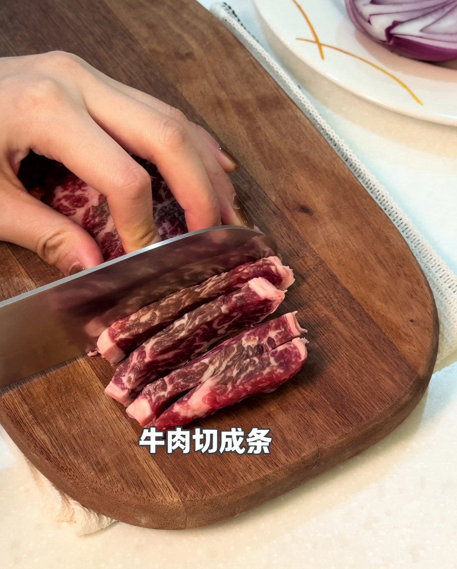 Primo piano di manzo crudo tagliato a strisce su un tagliere di legno.