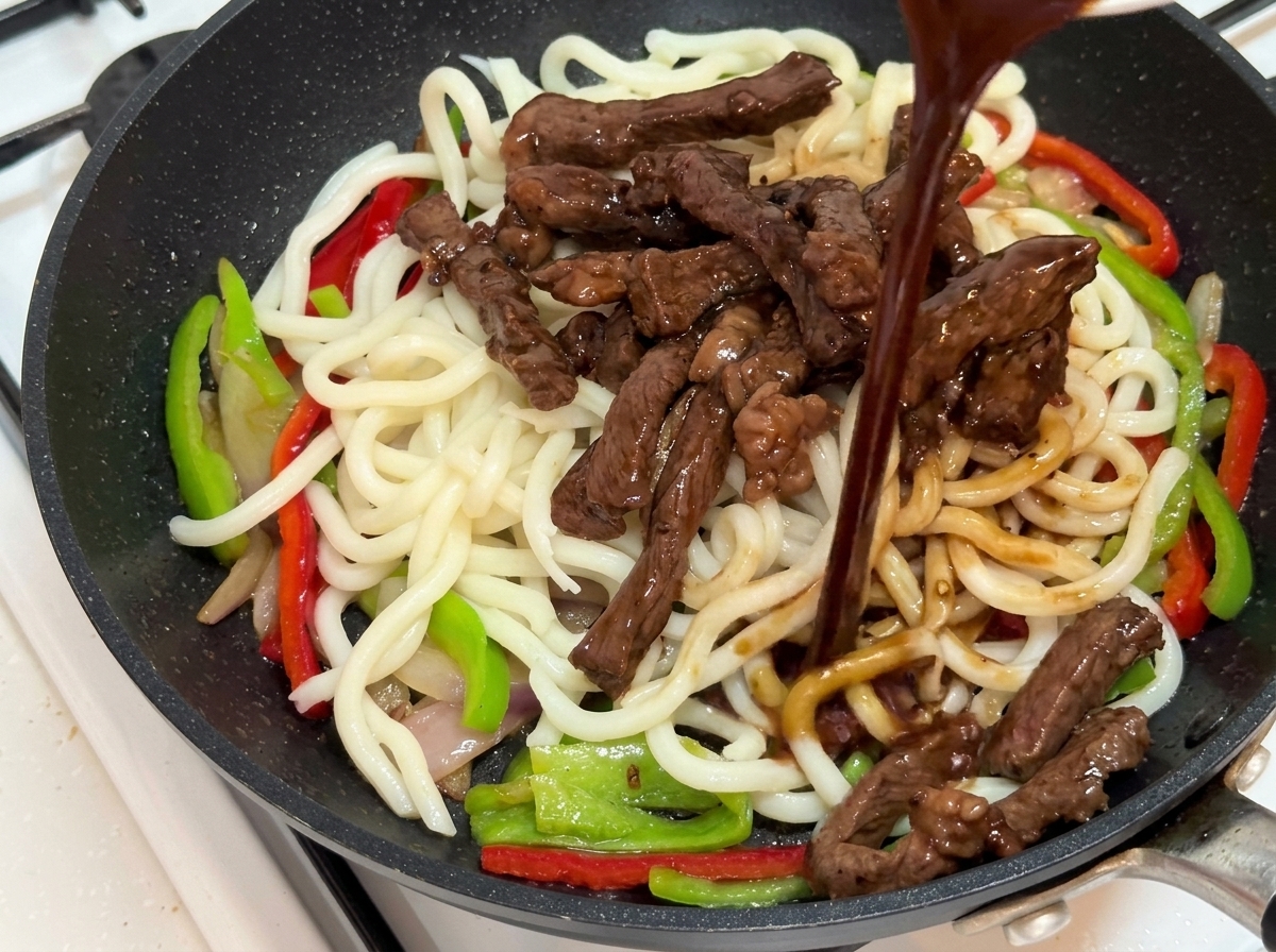 Salsa al pepe nero versata sugli ingredienti del stir-fry.