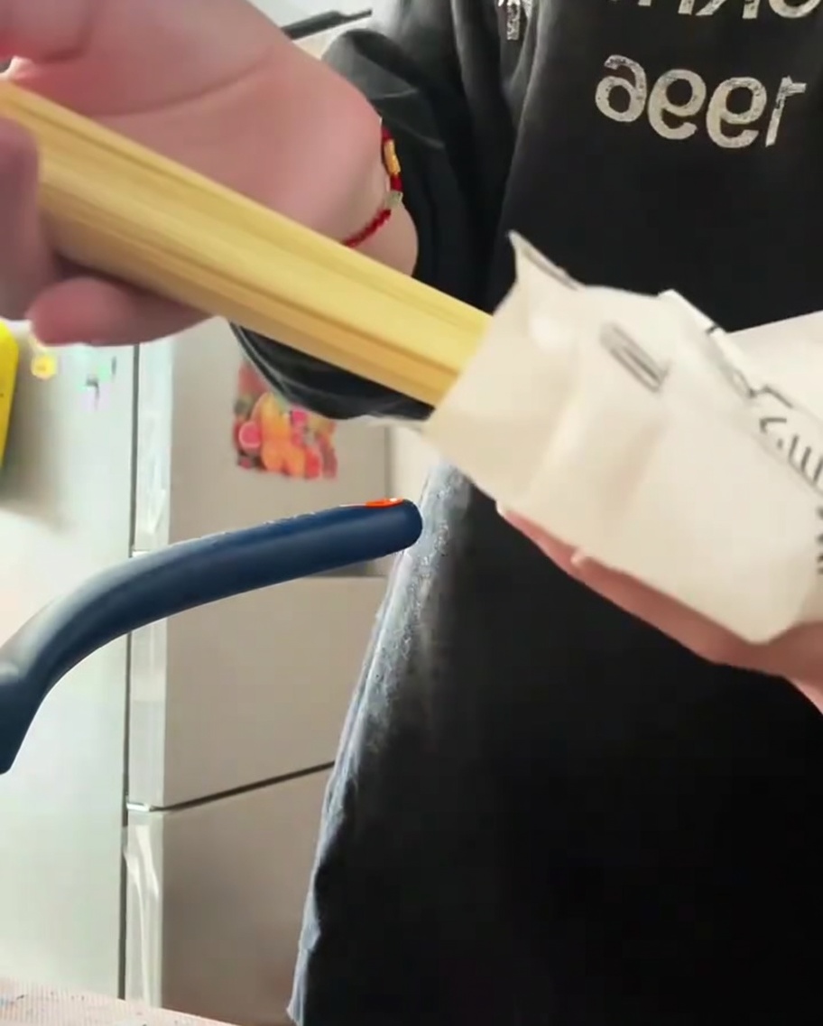 Noodle di ramen secchi aggiunti a una pentola di brodo Tonkotsu che sobbolle.