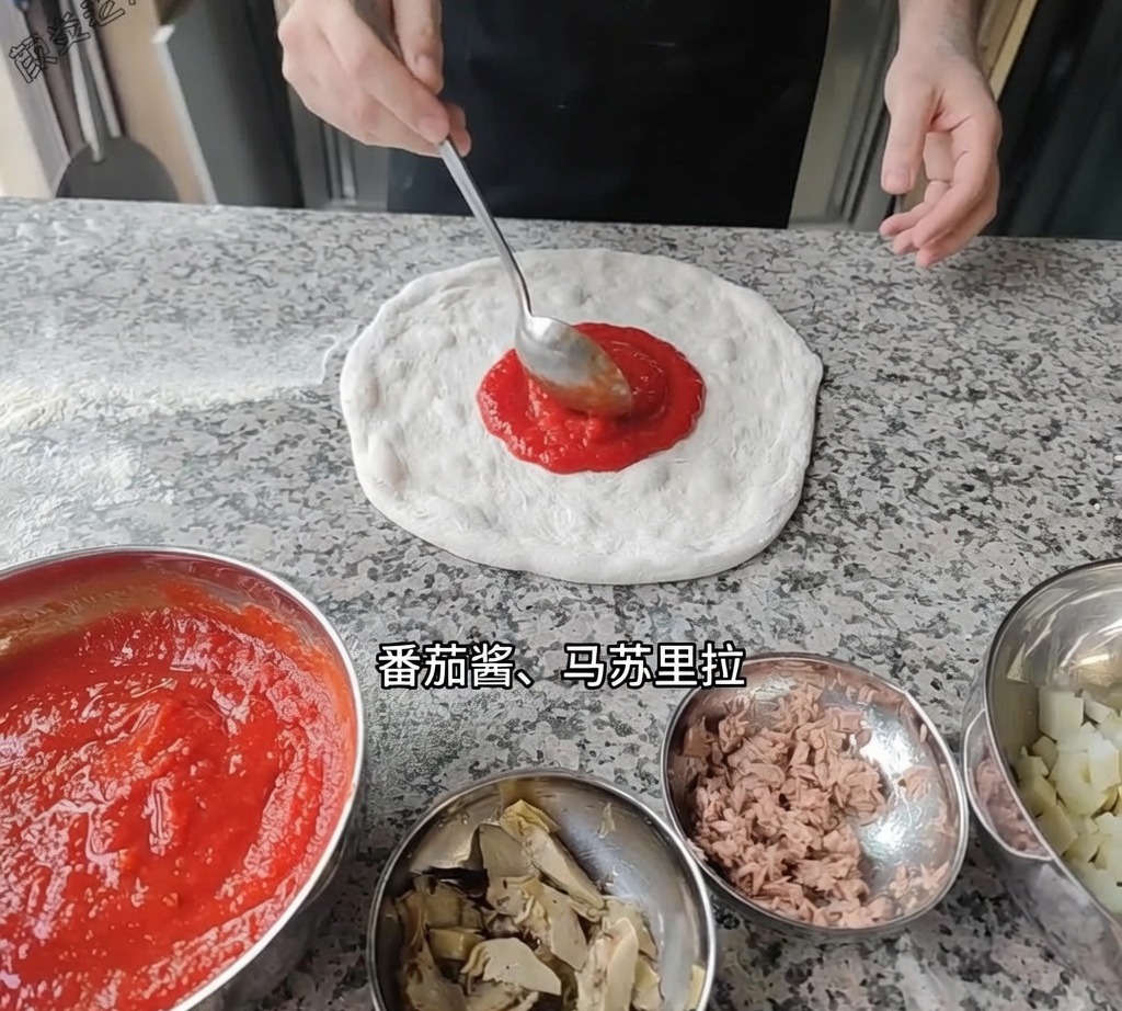 Un mestolo che stende salsa di pomodoro rossa e liscia sulla base dellimpasto.