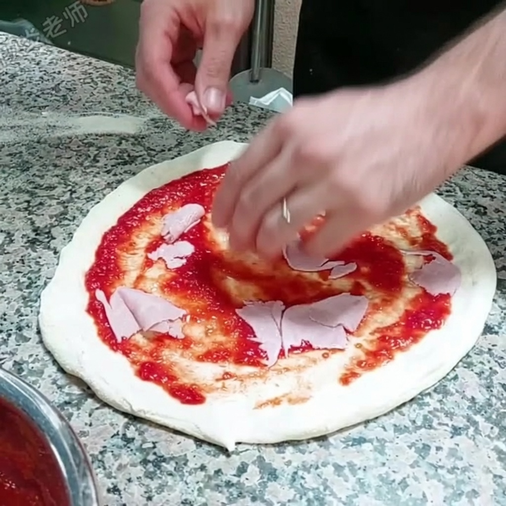 Fette sottili di prosciutto posizionate sopra la base di pizza coperta di salsa di pomodoro.