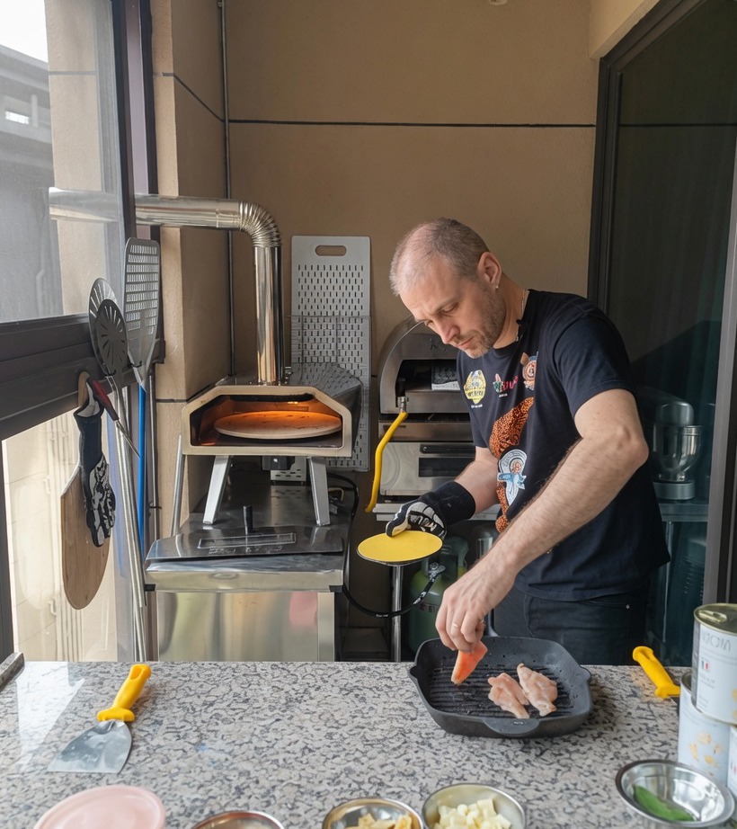 Primo piano di pezzetti di pollo che cuociono su una piastra in ghisa ben calda.