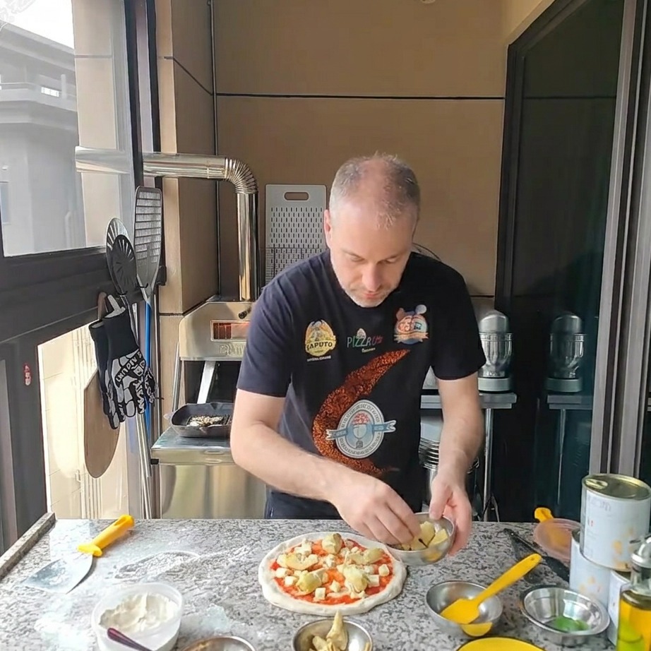 Pezzetti di carciofi disposti sulla pizza coperta di mozzarella.