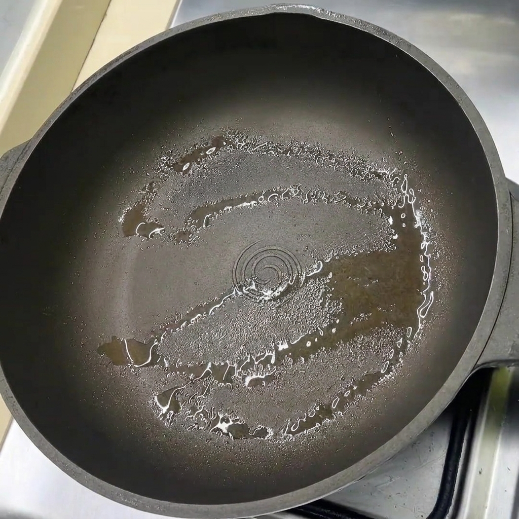 Fette di pancetta disposte in una padella leggermente oliata.