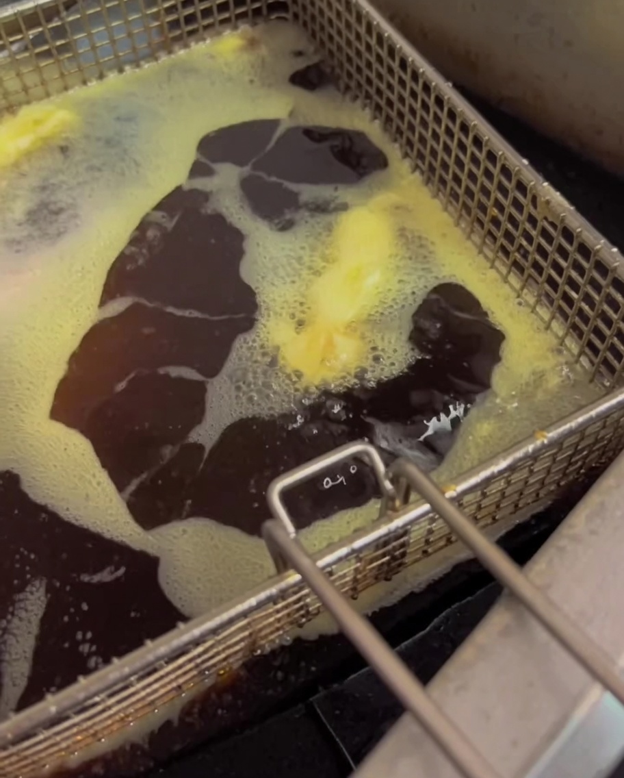 Fagiolini che friggono in olio bollente in una friggitrice.