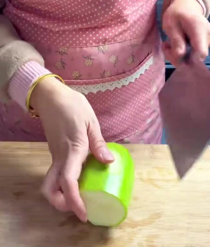 Cubetti di chayote tagliati in modo uniforme su un tagliere di legno.