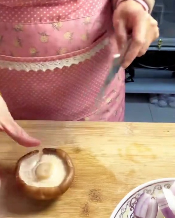 Funghi shiitake freschi affettati a strisce sottili e uniformi su un tagliere di legno.