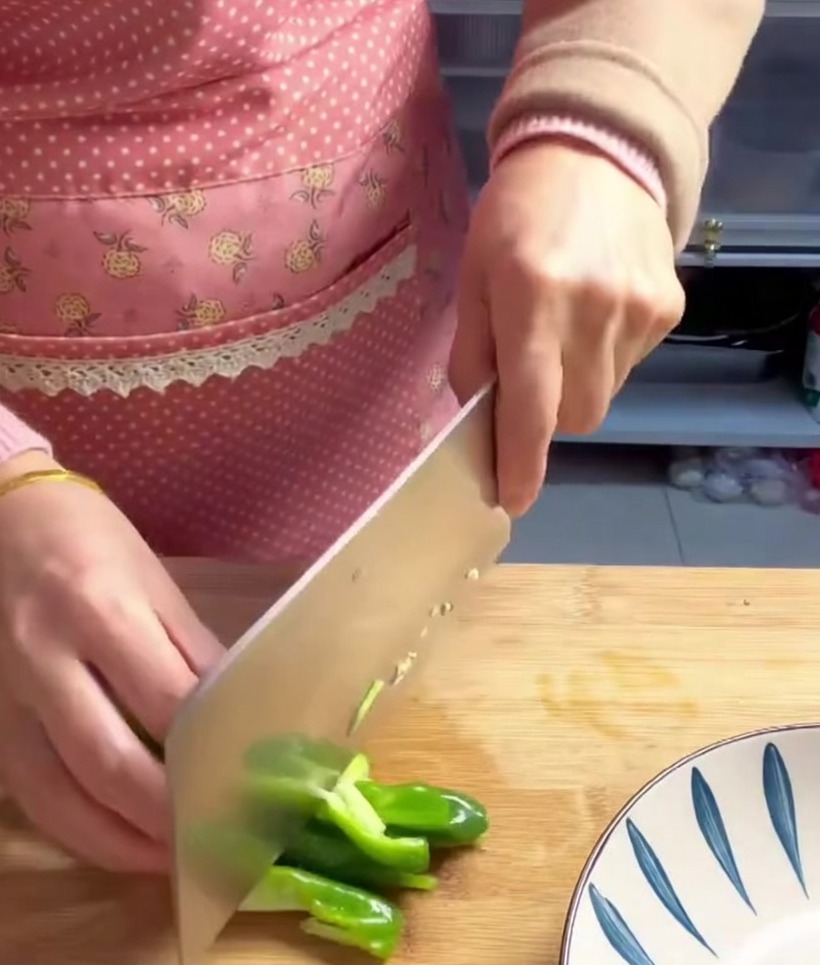 Pezzi di peperone verde tagliati e pronti per essere aggiunti alla pentola.