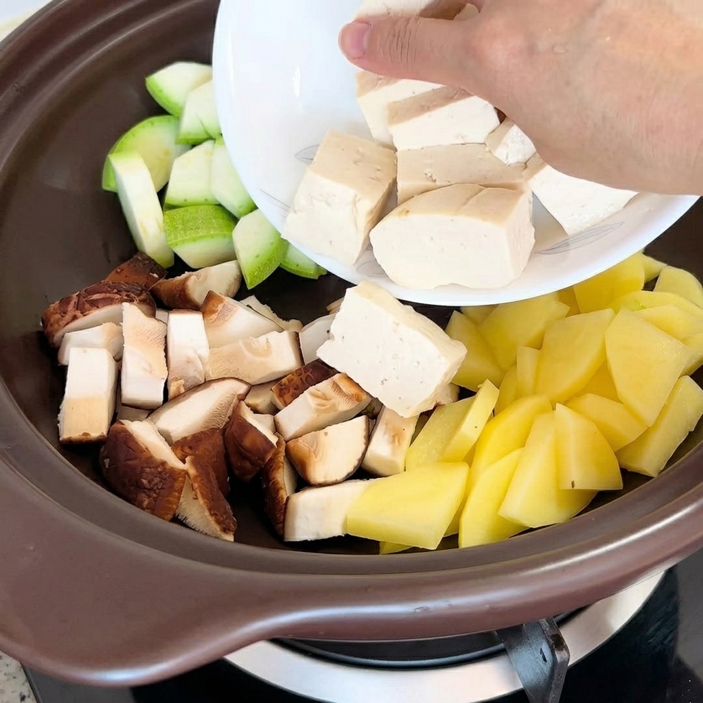 Pezzi di tofu e vongole essiccate aggiunti al tegame.