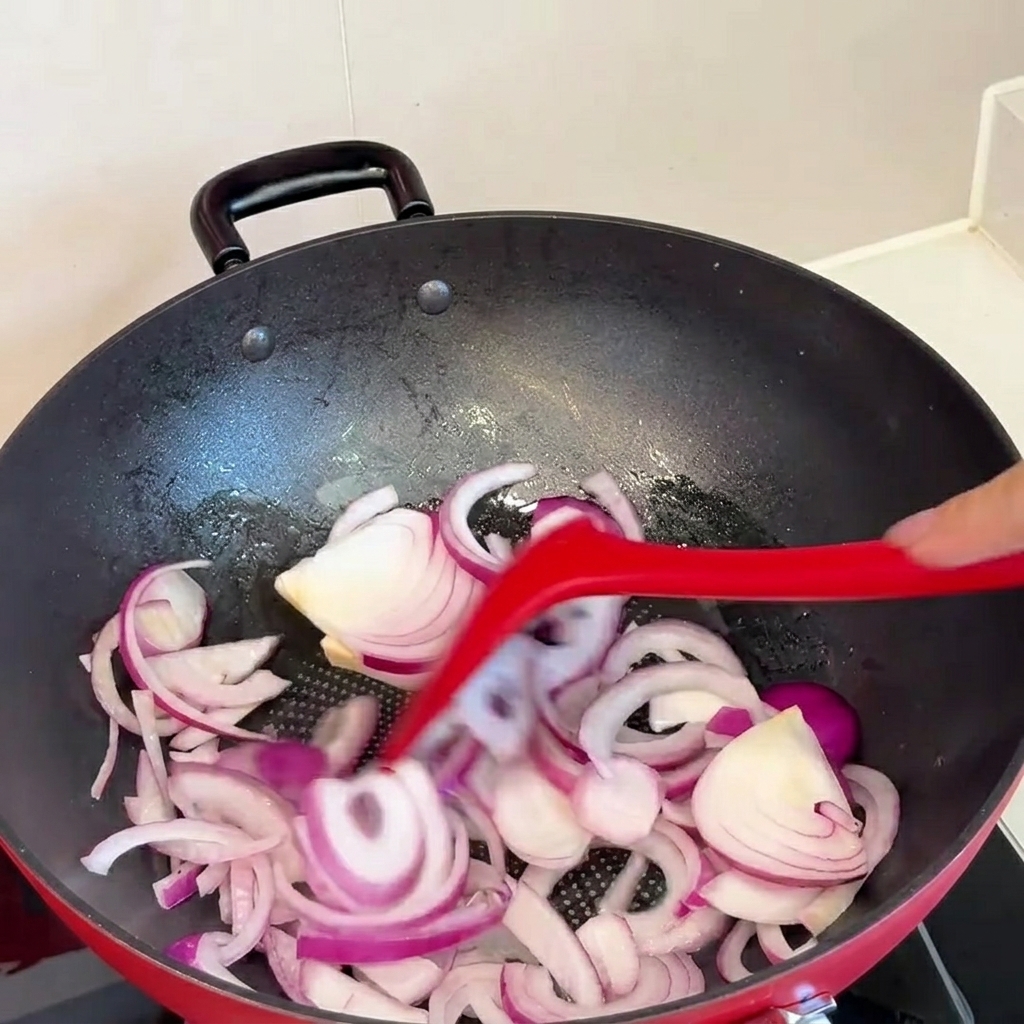 Il kimchi viene aggiunto nella padella con le cipolle soffritte.