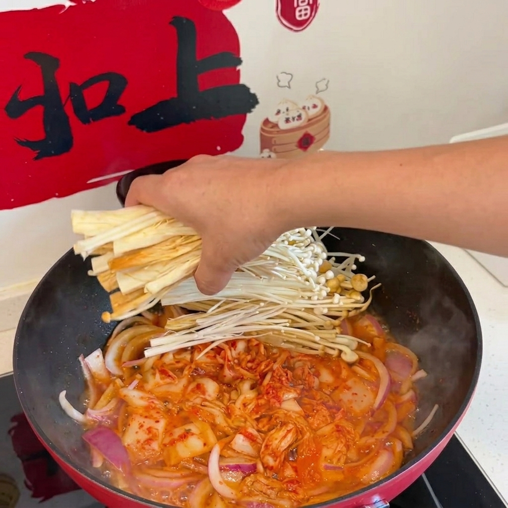 Funghi enoki, zucchine, germogli di soia e tofu vengono aggiunti nella padella.