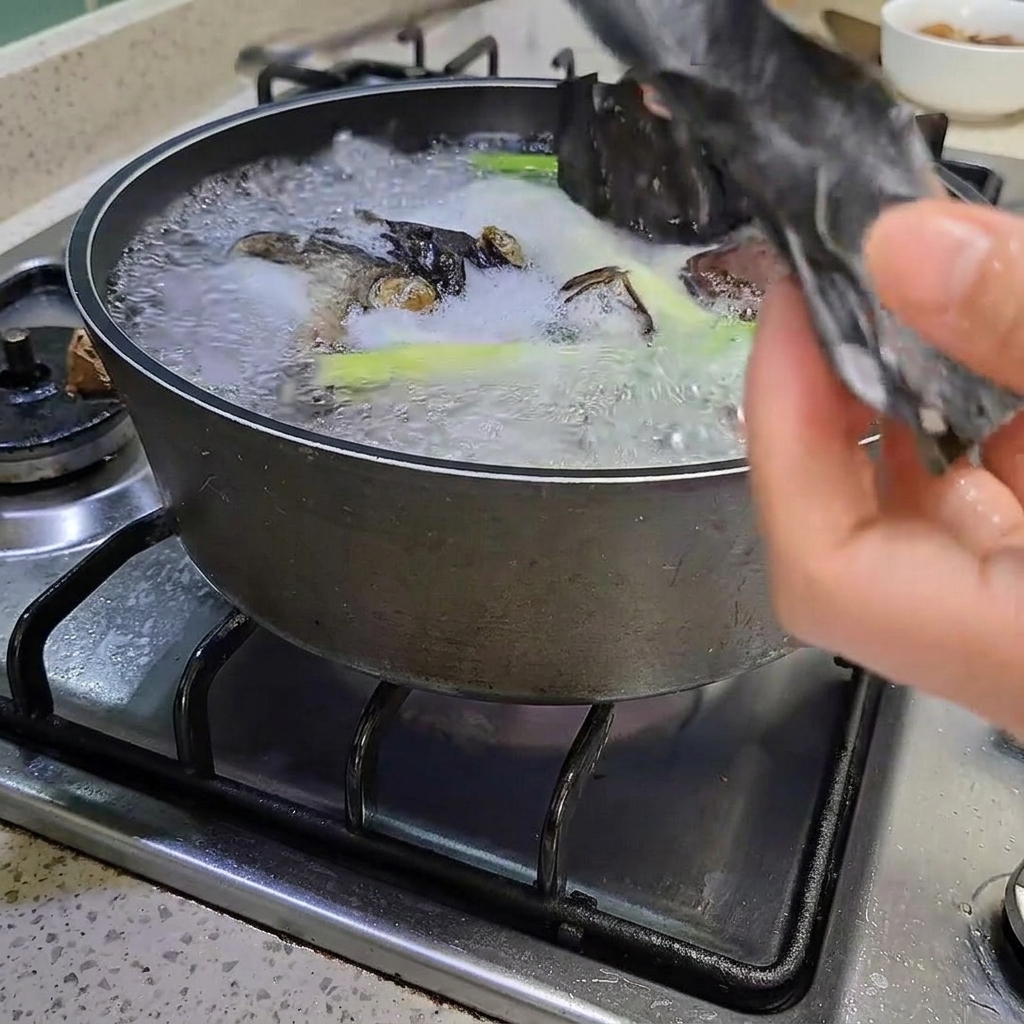 Pinze che rimuovono un pezzo di alga kelp dalla pentola bollente.