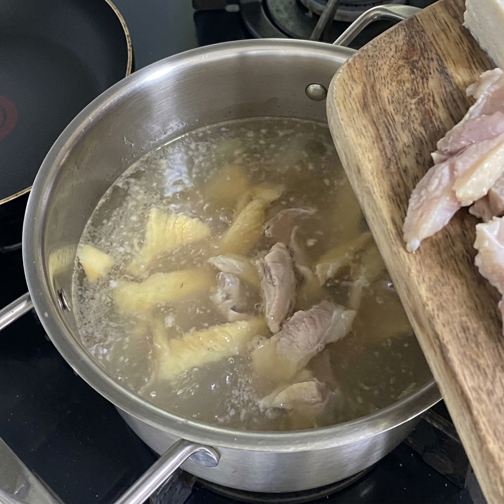 Cubetti di tofu fresco aggiunti al brodo di pollack bollente e chiaro.