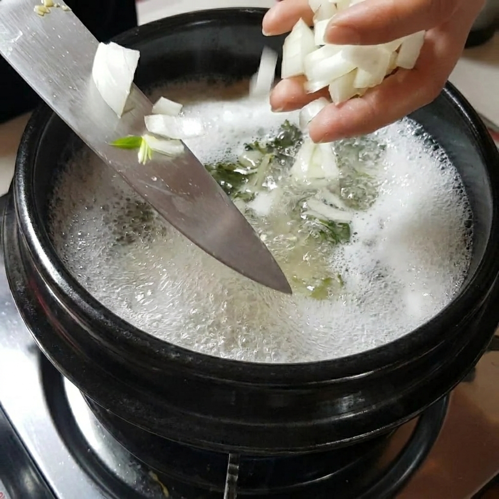 Mani che aggiungono cipolle e funghi affettati nella pentola di zuppa che sobbolle.