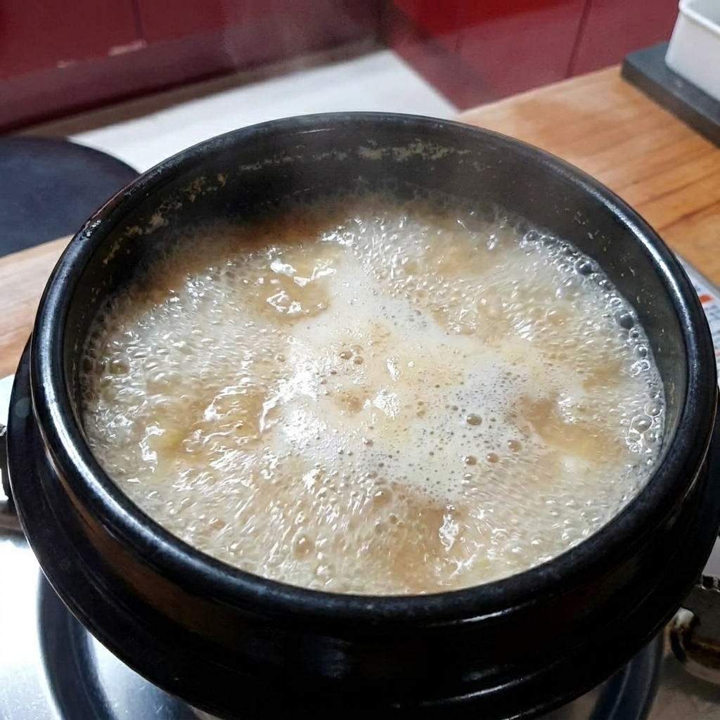 Aglio tritato aggiunto allo stufato di pasta di soia bollente.