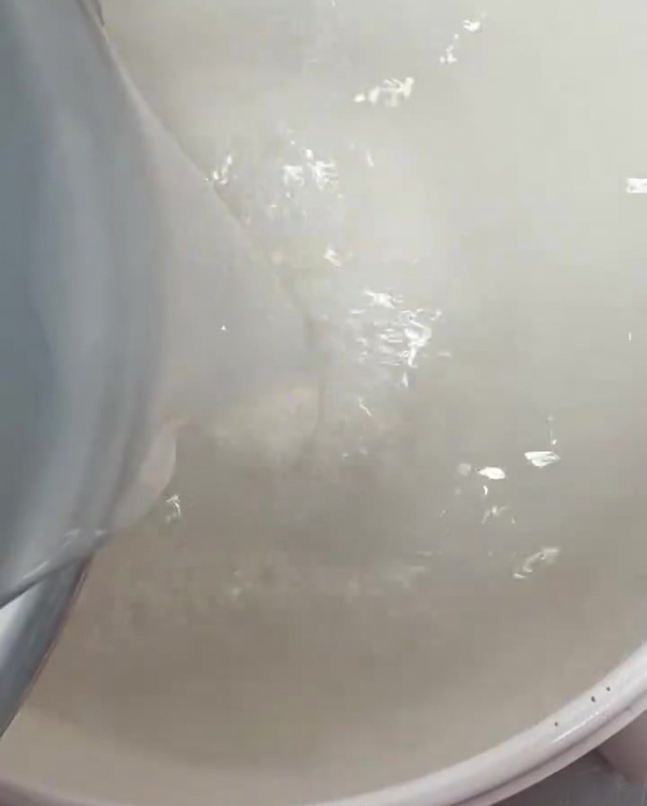 Acqua di riso bianca versata in una pentola capiente.