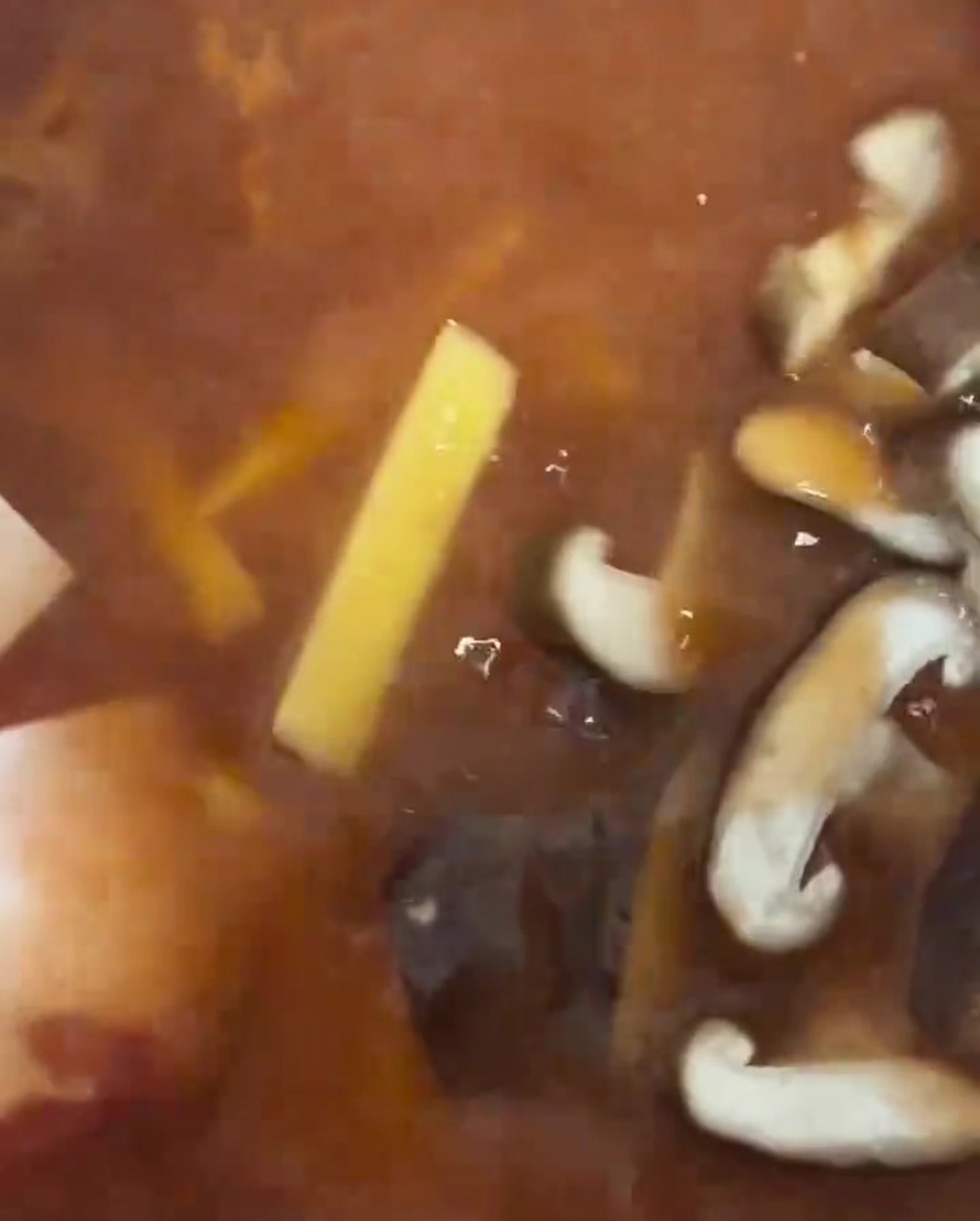 Fette di funghi shiitake freschi messe nello stufato.