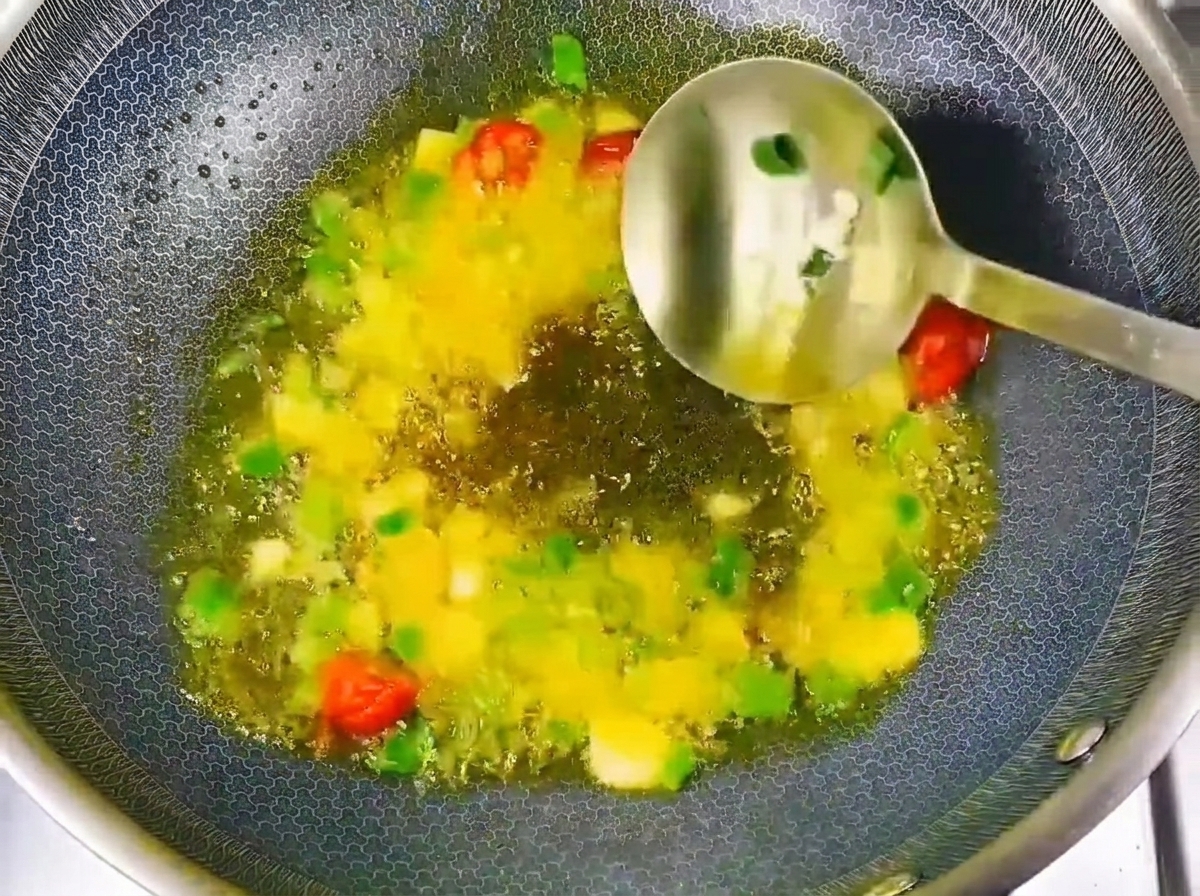 Pasta di soia e salsa di soia aggiunte agli aromi soffritti nel wok.