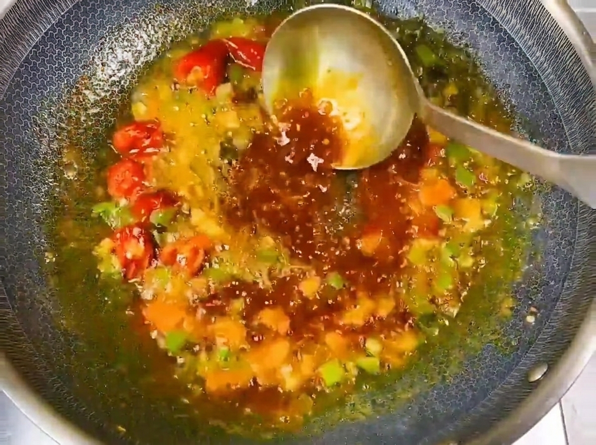 Acqua versata nel wok con la base aromatica per formare il brodo.
