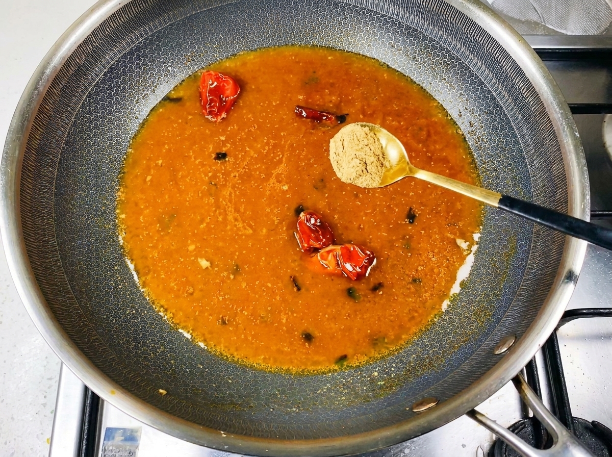 Spezie in polvere spolverate nel brodo in ebollizione nel wok.