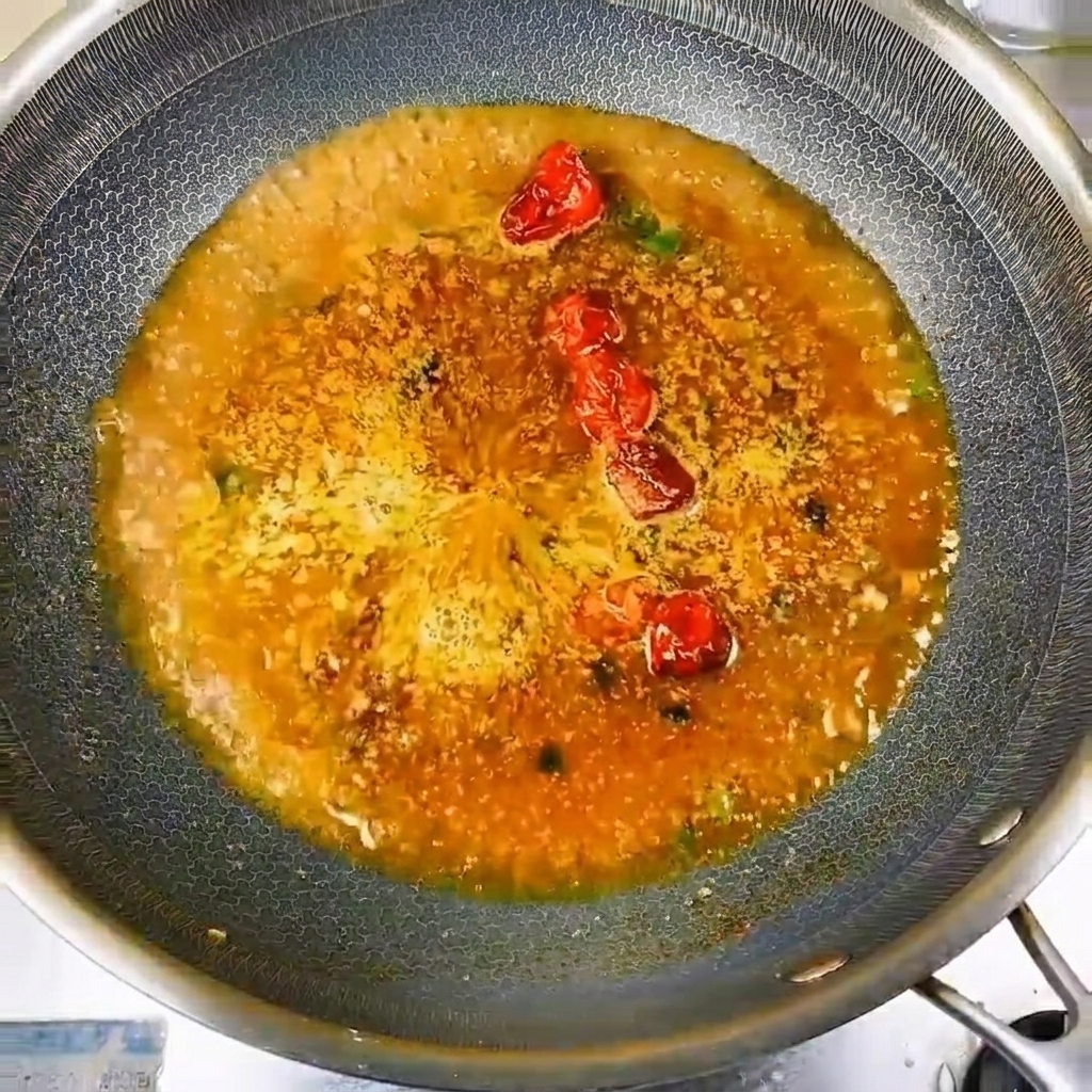 Piccoli pesci disposti a cerchio nel liquido di cottura in ebollizione.