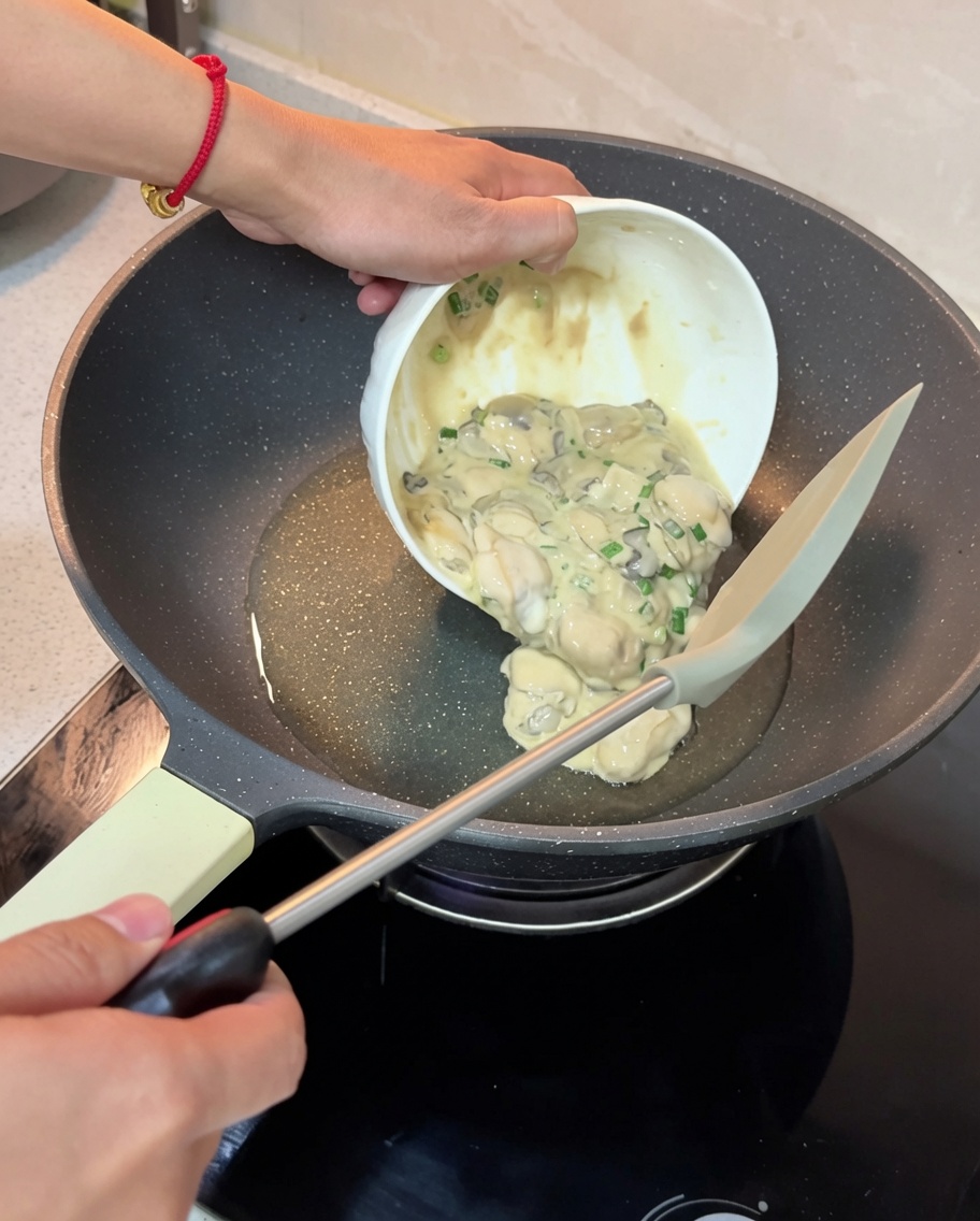 Il mix di ostriche e cipollotti versato in una padella calda e oliata per iniziare il processo di rosolatura.