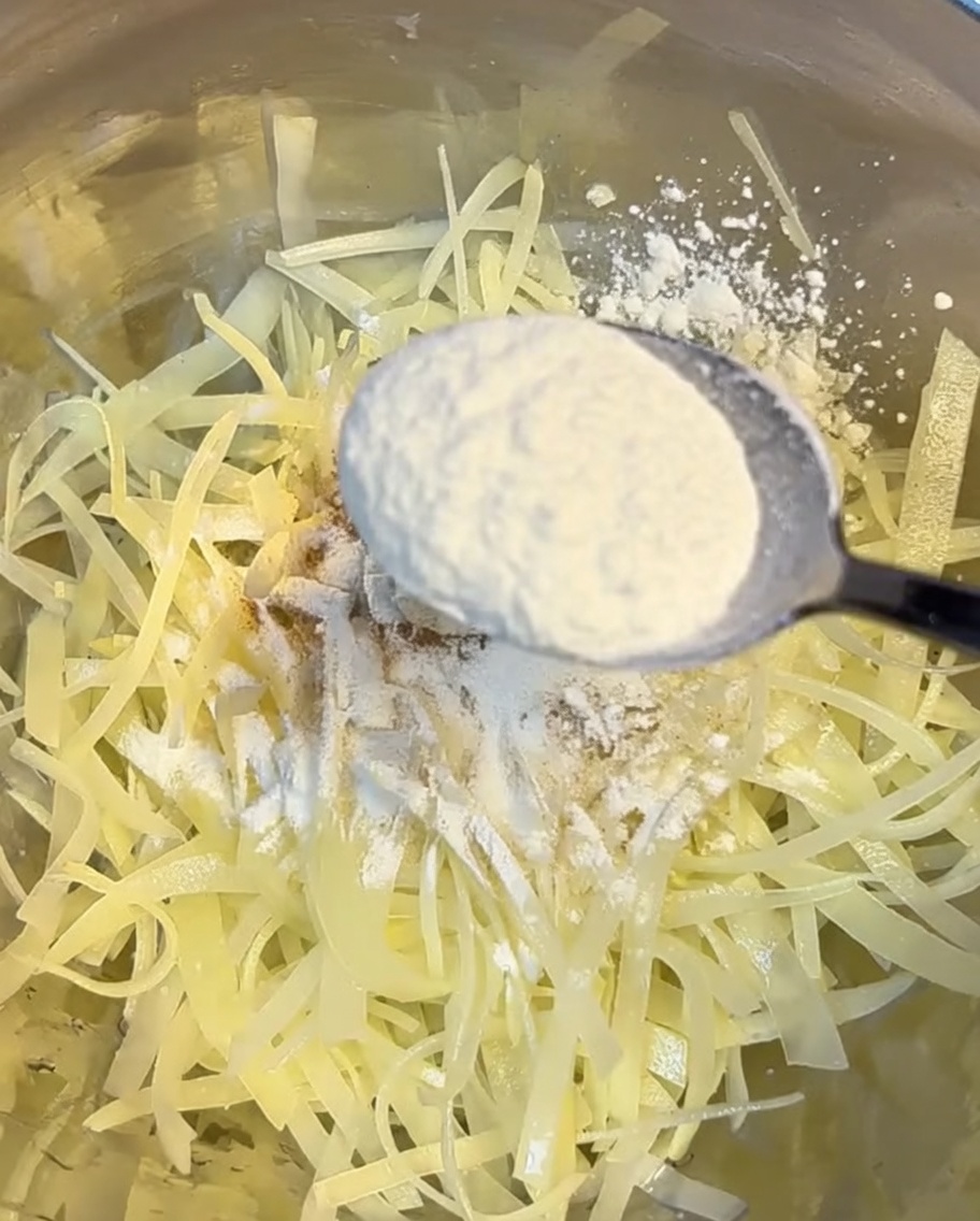 Ciotola con patate grattugiate rivestite da una miscela di farina e fecola di mais.
