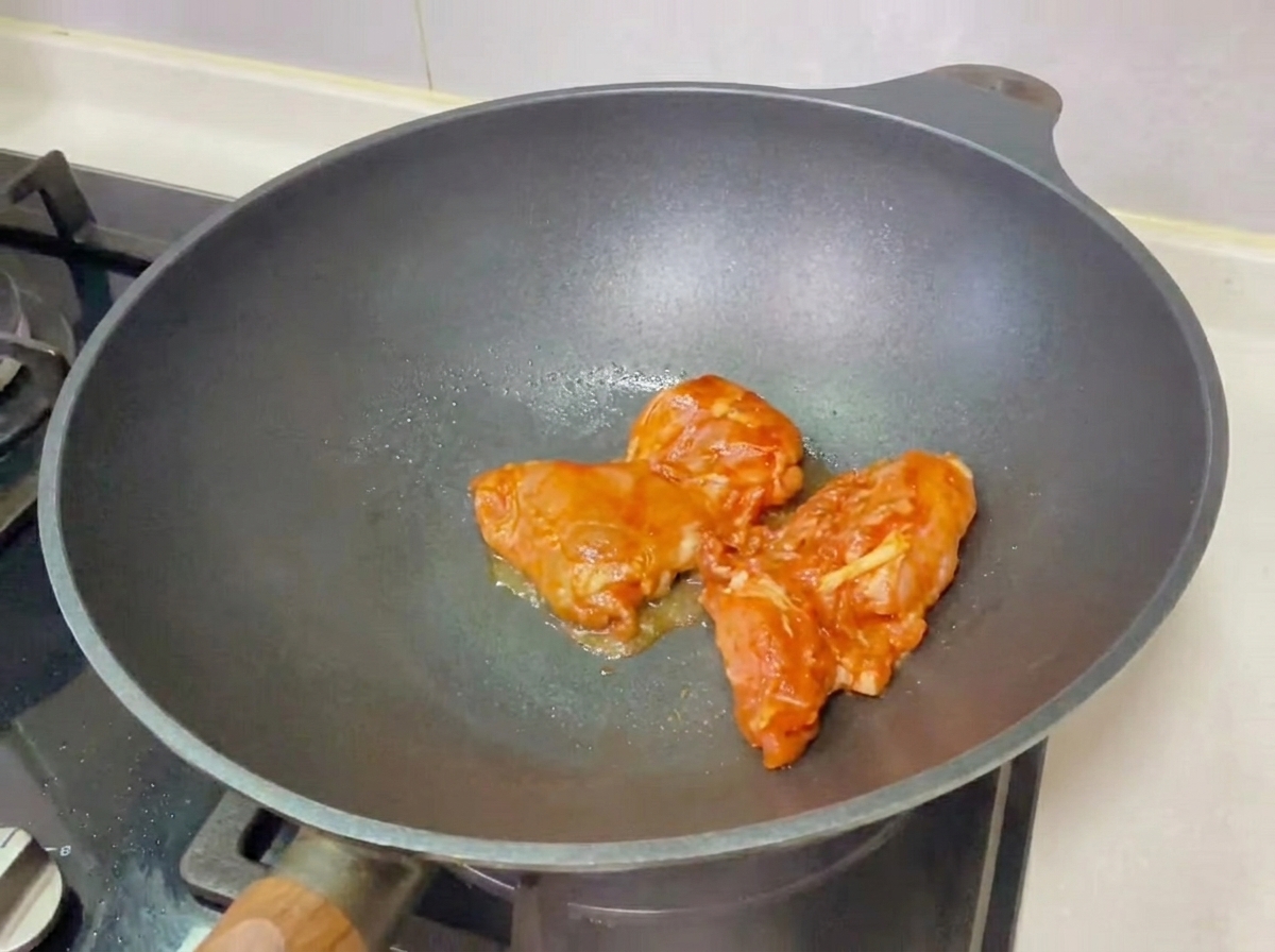 Un hamburger di pollo teriyaki assemblato su un tagliere di legno, pronto per essere mangiato.