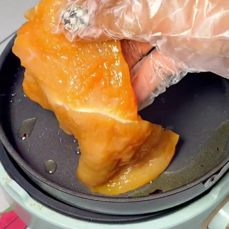 Fette di pollo marinate che dorano magnificamente in una padella calda e oliata.