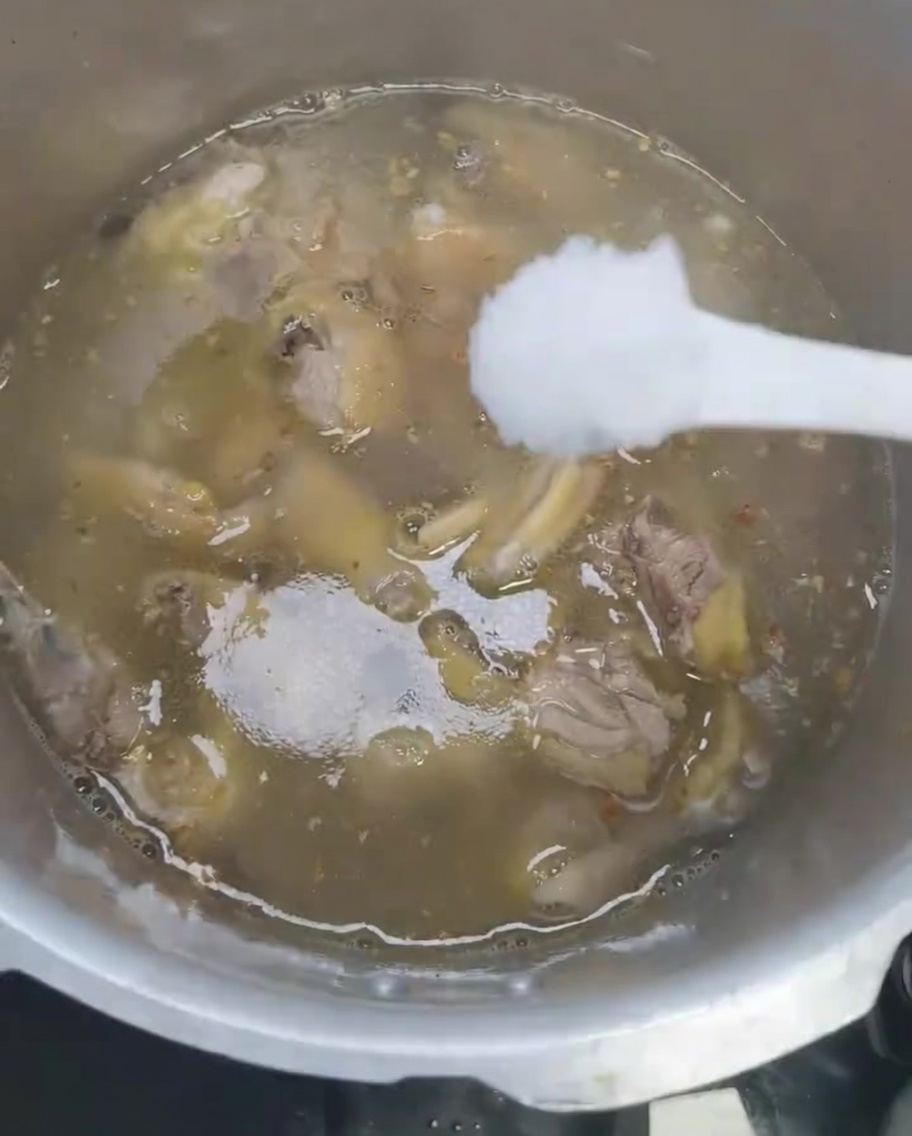 Sale aggiunto alla zuppa di pollo nella pentola a pressione.