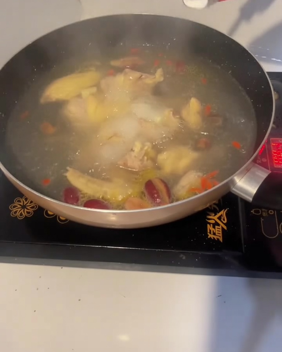 Un cucchiaio di sale aggiunto alla zuppa di pollo in ebollizione per insaporirla.