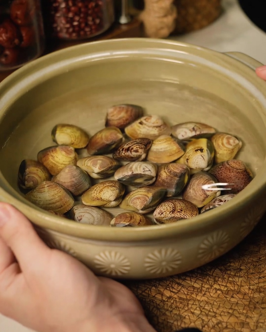 Vongole fresche immerse in una ciotola di ceramica con acqua per eliminare la sabbia.