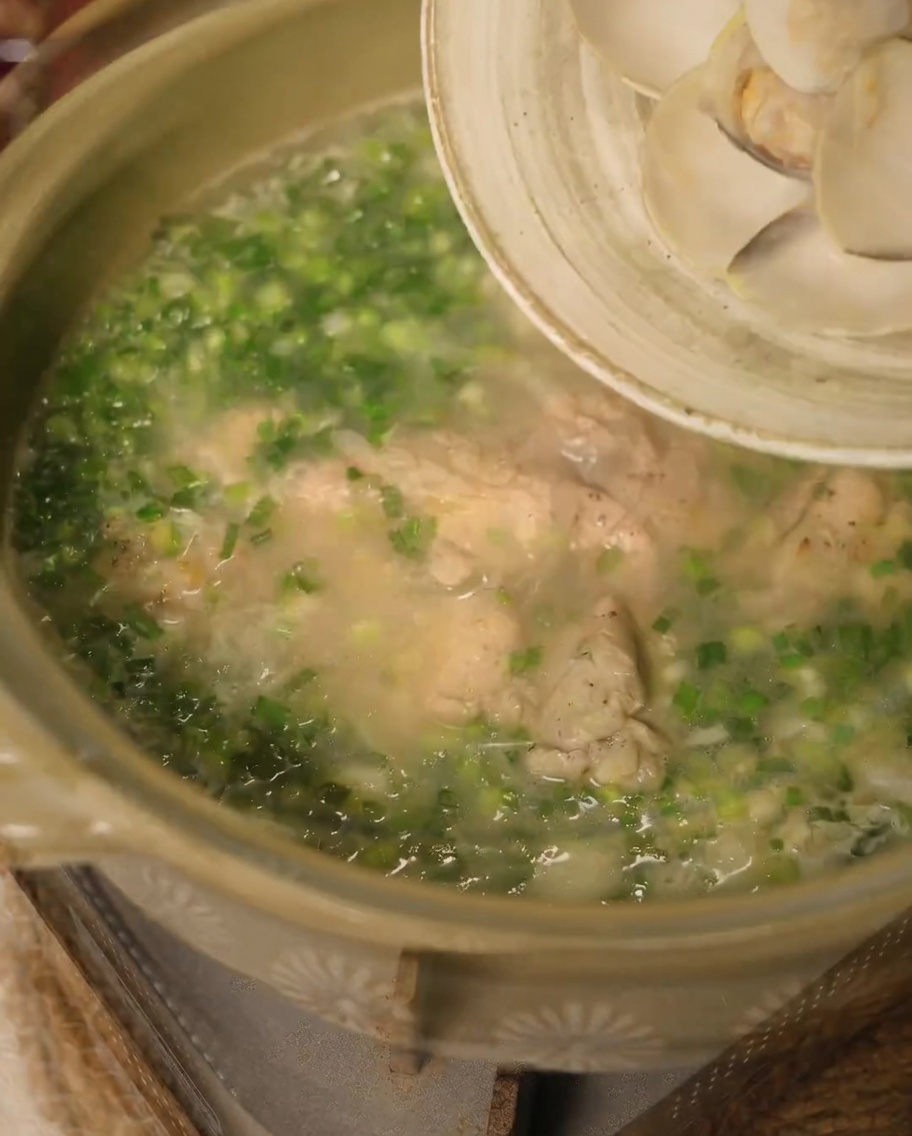 Strisce di cipolla e spicchi daglio che rosolano nel grasso di pollo fuso in padella.