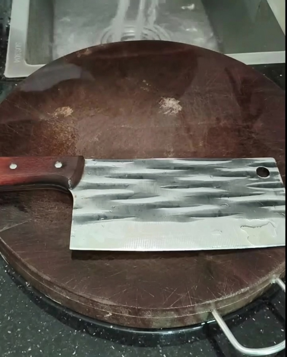 Pezzi di pollo lavati in uno scolapasta sotto il rubinetto della cucina.