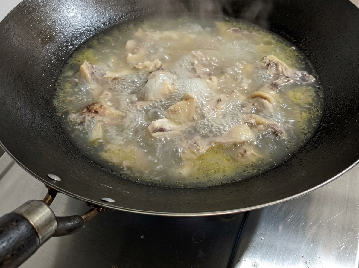 Zuppa di pollo che sobbolle mentre si aggiunge il sale.