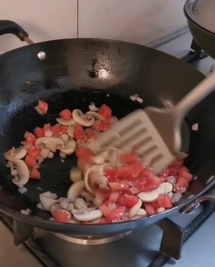 Verdure a cubetti e funghi che cuociono in un wok caldo con olio doliva.