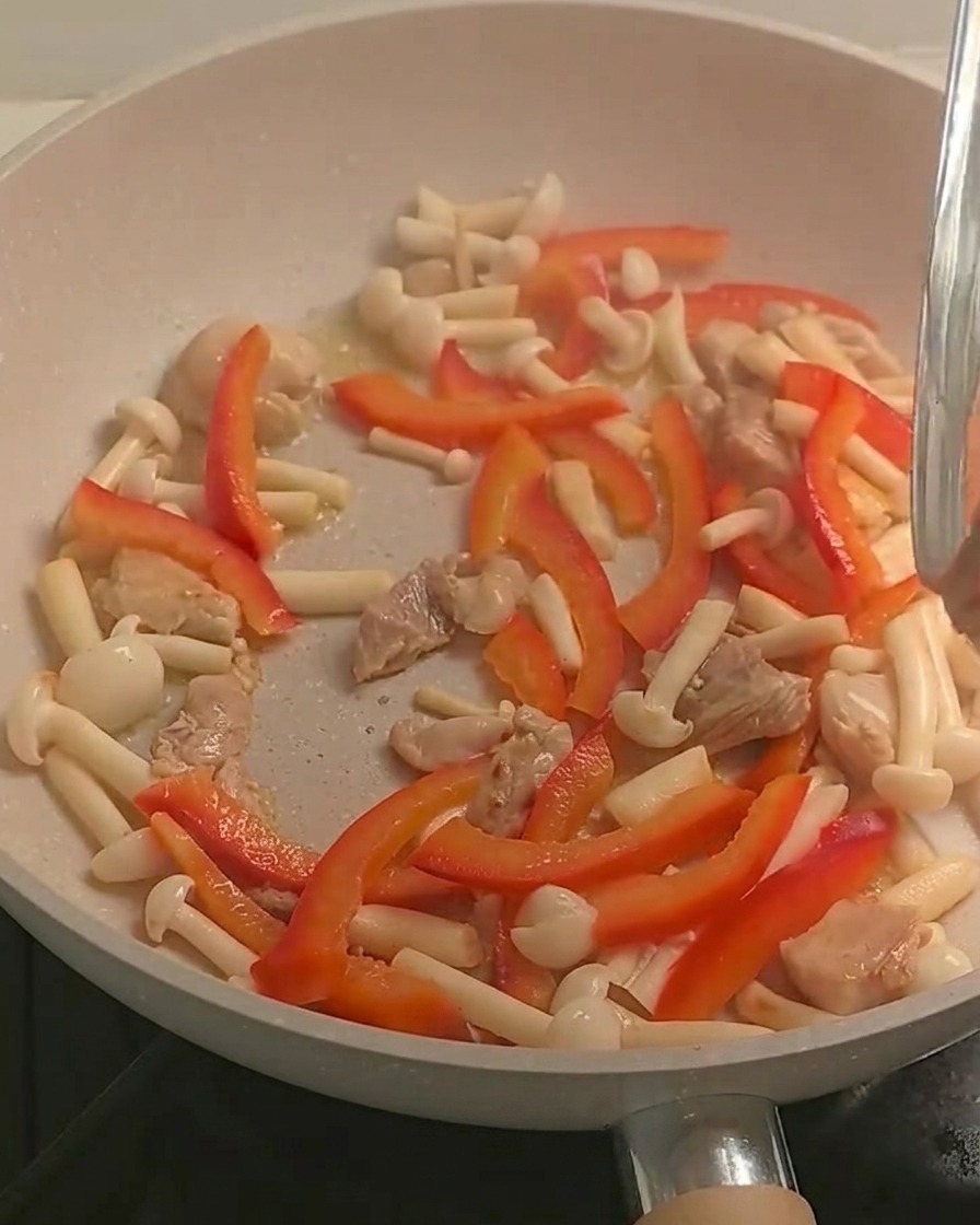 Fusilli cotti aggiunti alla padella contenente il pollo saltato e le verdure.