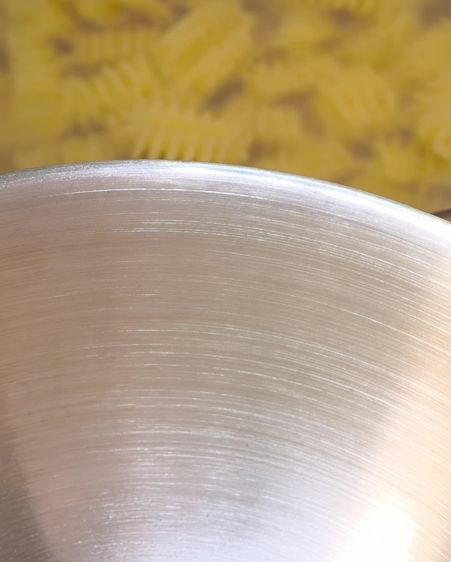 Acqua di cottura della pasta calda versata nella ciotola, mentre interagisce con il burro e i condimenti.