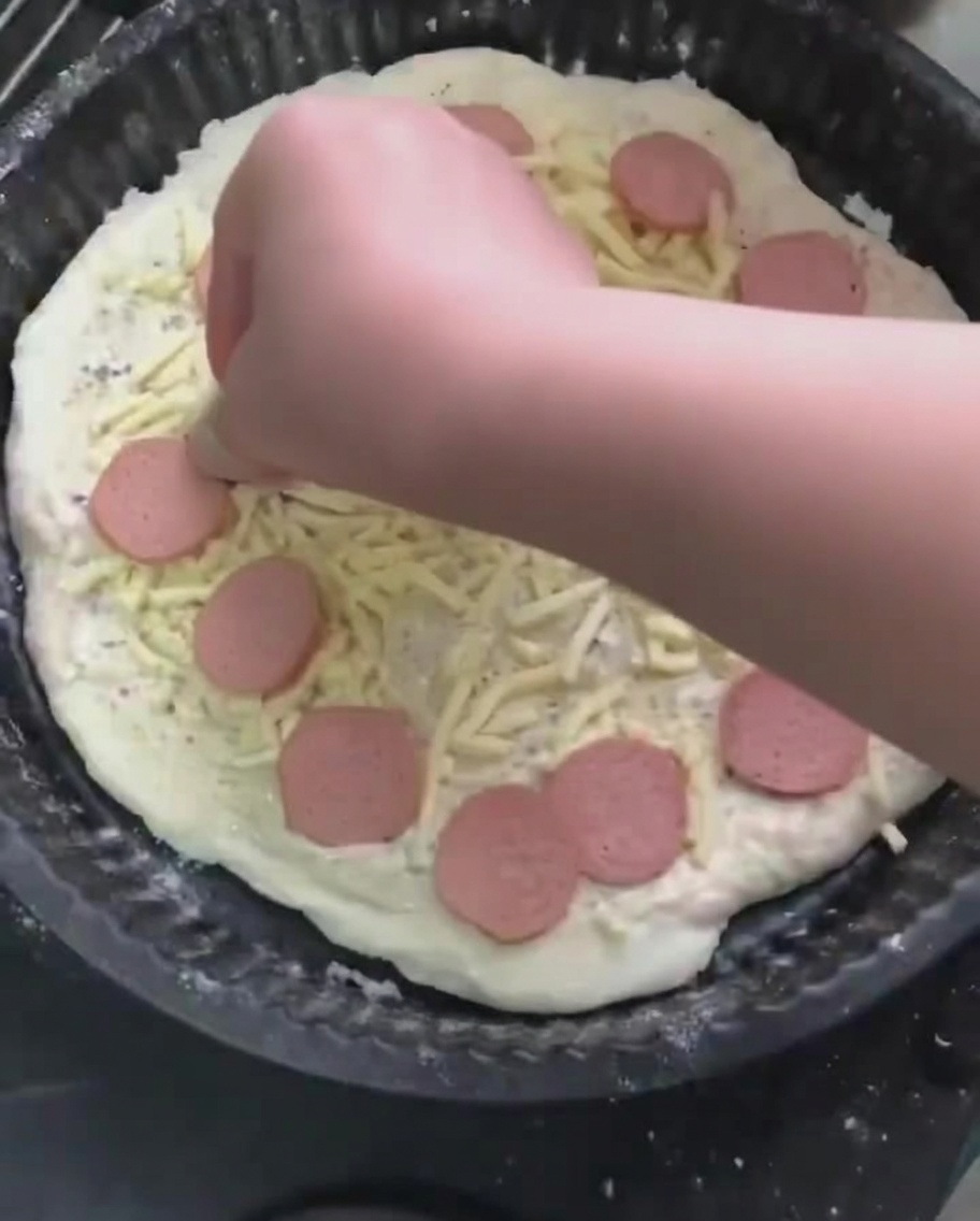 Fette di salsiccia posizionate sopra lo strato di mozzarella.