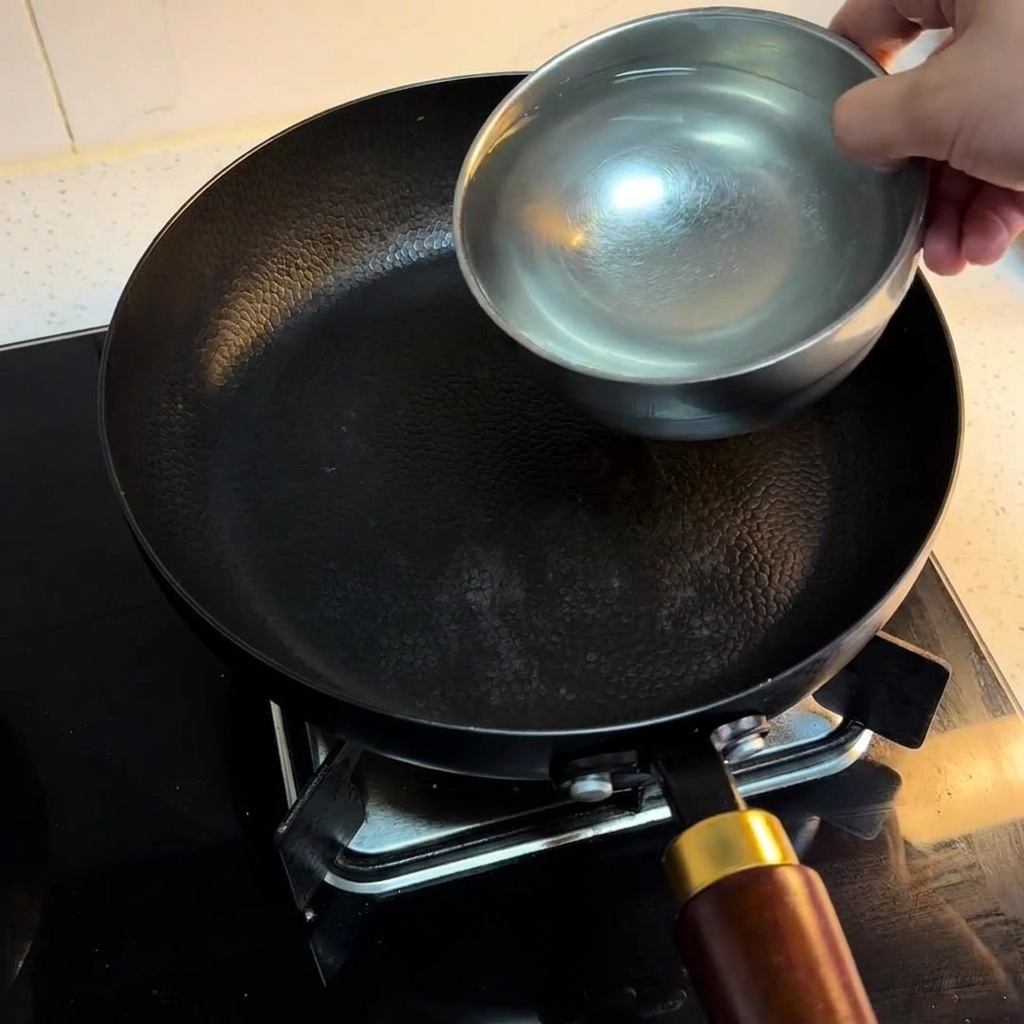 Tre ciotole dacqua versate in una padella nera su un fornello.