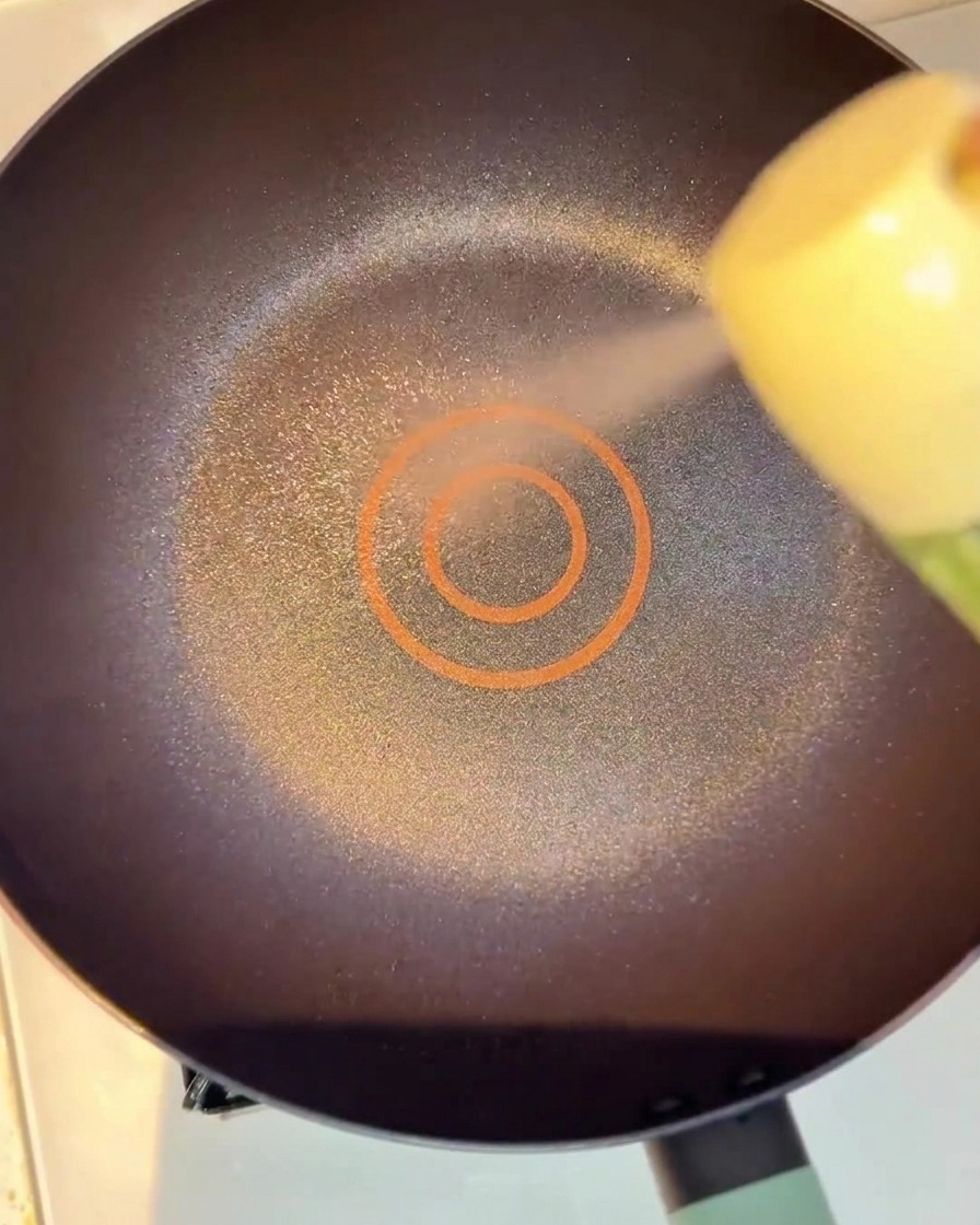 Strisce di manzo marinate che sfrigolano in padella mentre iniziano a dorarsi.
