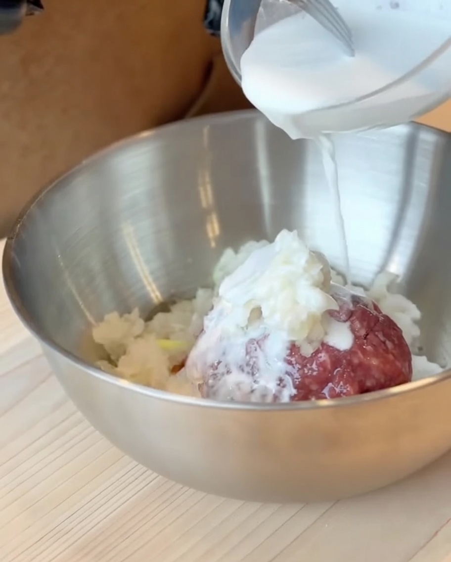 La pastella di latte e farina di patate dolci versata sul composto di carne macinata in una grande ciotola.