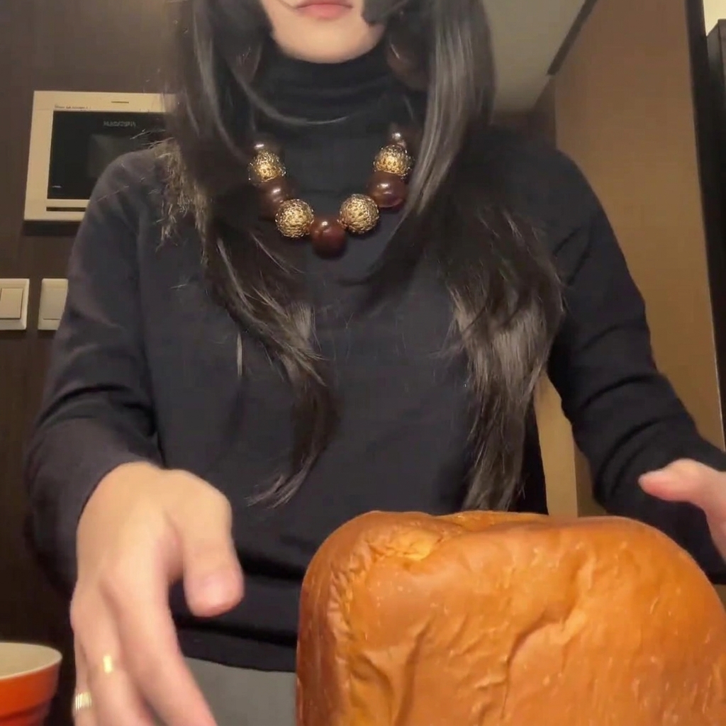 Pagnotta di pane appena sfornata e dorata, tagliata in fette spesse e uniformi su un tagliere.